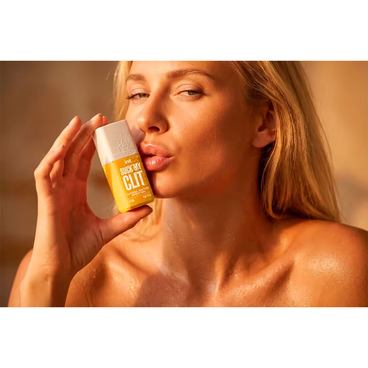 Flacon gel Suck My Clit mangue Intt tenu dans une main échelle fond blanc
